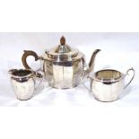 AN EARLY 20TH CENTURY SILVER PLATED THREE PIECE TEA SERVICE Having a carved wooden acorn finial