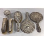 TWO EARLY 20TH CENTURY SILVER VANITY HAND MIRRORS Having embossed scrolled decoration, together with