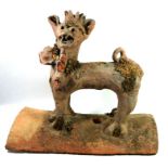 AN ANTIQUE TERRACOTTA ROOF RIDGE TILE In the form of an archaic grotesque beast. (w 42cm x h 36cm)