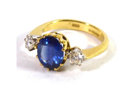 GASSAN, AN 18CT GOLD, SAPPHIRE AND DIAMOND THREE STONE RING The oval ...