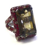 AN 18CT WHITE GOLD, CITRINE, GARNET AND DIAMOND RING Having a baguette cut citrine edged with an