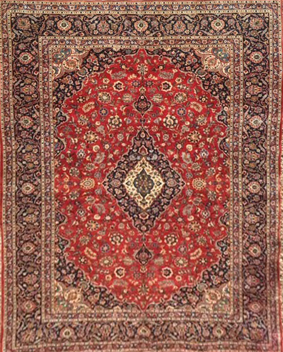 A KURK KASHAN WOOLLEN RUG OF CARPET PROPORTIONS The pendant medallion and floral decoration on a red