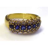 AN 18CT GOLD, SAPPHIRE AND DIAMOND RING The line of round cut sapphires flanked by diamond (size M).