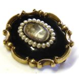 A VICTORIAN YELLOW METAL, SEED PEARL AND BLACK ENAMEL MOURNING BROOCH Rectangular form, with