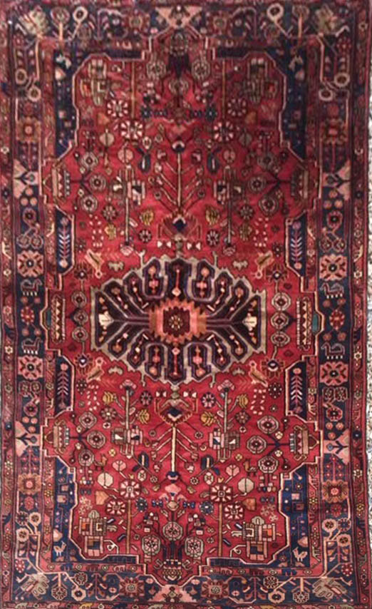 A HAMADAM WOOLLEN RUG The central medallion on a red field, flanked by floral designs and a