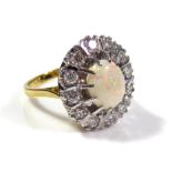 AN 18CT GOLD, OPAL AND DIAMOND CLUSTER RING Having a cabochon cut opal edged with round cut diamonds