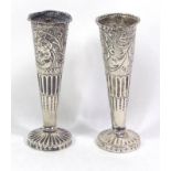 A PAIR OF VICTORIAN SILVER VASES Having embossed floral decoration, together with eight teaspoons