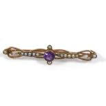 A VINTAGE 9CT GOLD AMETHYST AND SEED PEARL BROOCH The single round cut amethyst flanked by