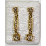 A PAIR OF 18CT GOLD AND DIAMOND DROP EARRINGS The row of round cut diamonds in geometric form mount.