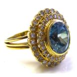 AN 18CT GOLD, NATURAL ZIRCON AND DIAMOND CLUSTER RING The oval cut stone edged with two rows of
