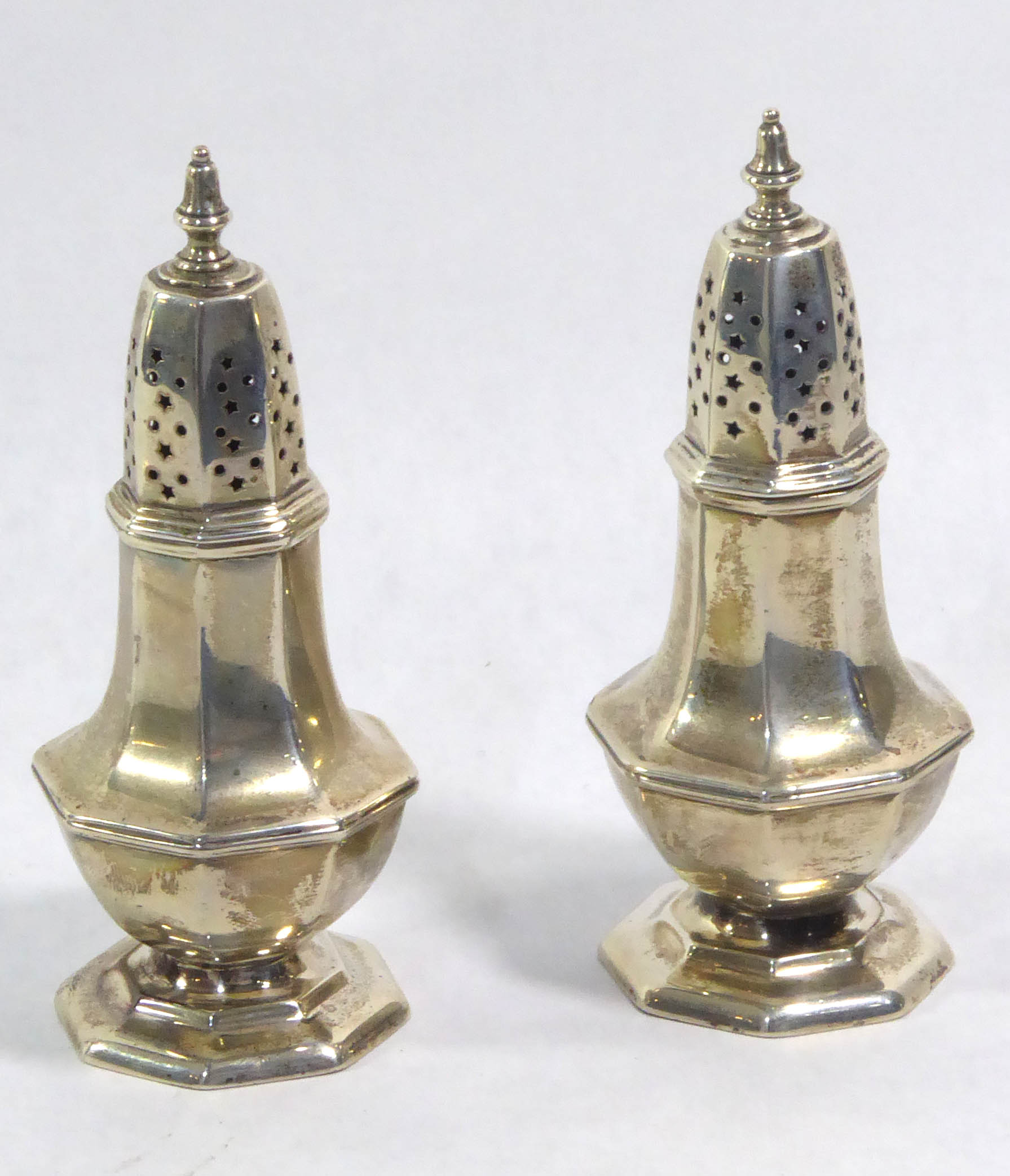 A PAIR OF EARLY 20TH CENTURY SILVER OCTAGONAL FORM PEPPERETTES With pierced dome, hallmarked