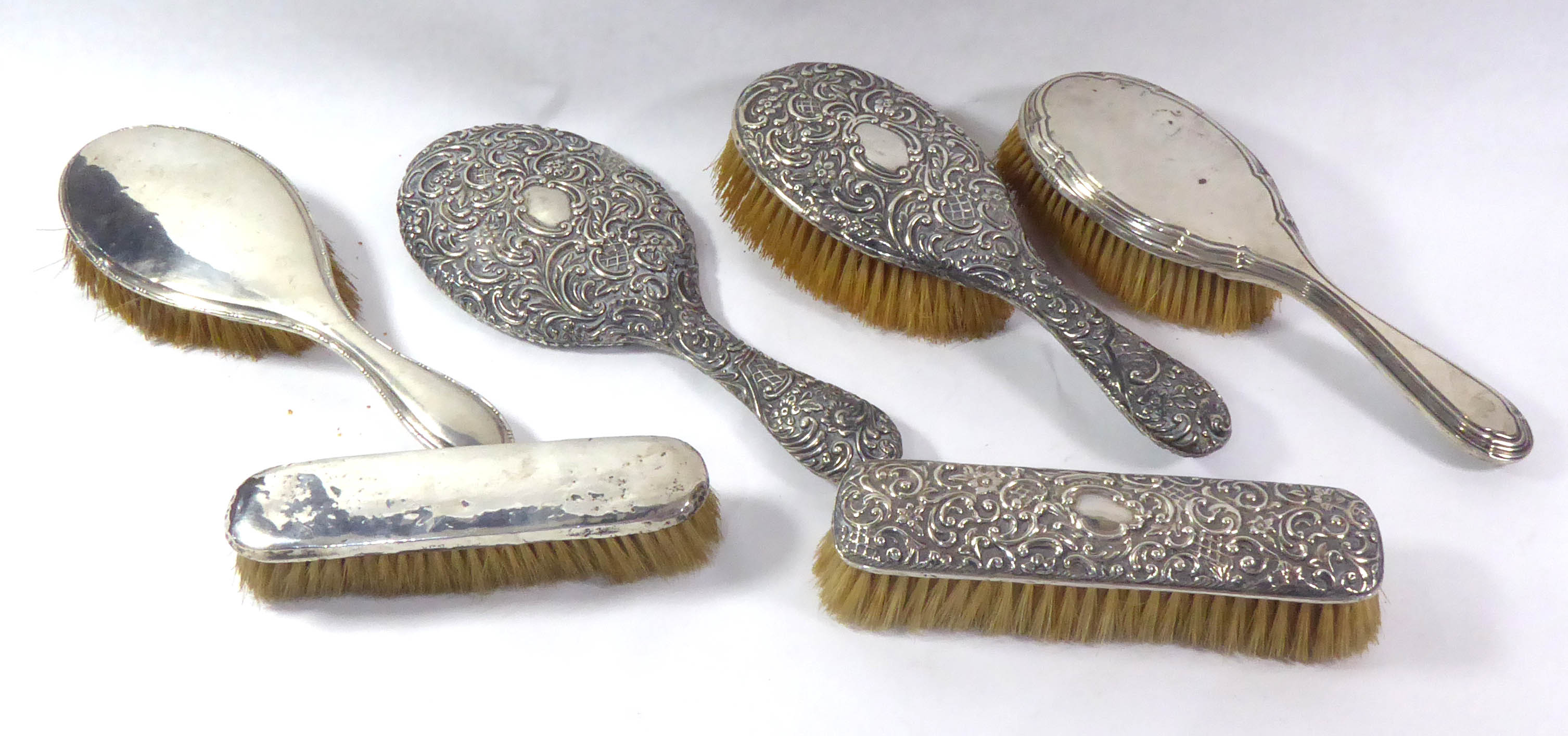 A VICTORIAN SILVER THREE PIECE VANITY SET Comprising a hand mirror, hair and clutter brush, with