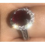 AN 18CT WHITE GOLD, RUBY AND DIAMOND RING Set with a 2ct oval ruby (1cm x 08cm) surround