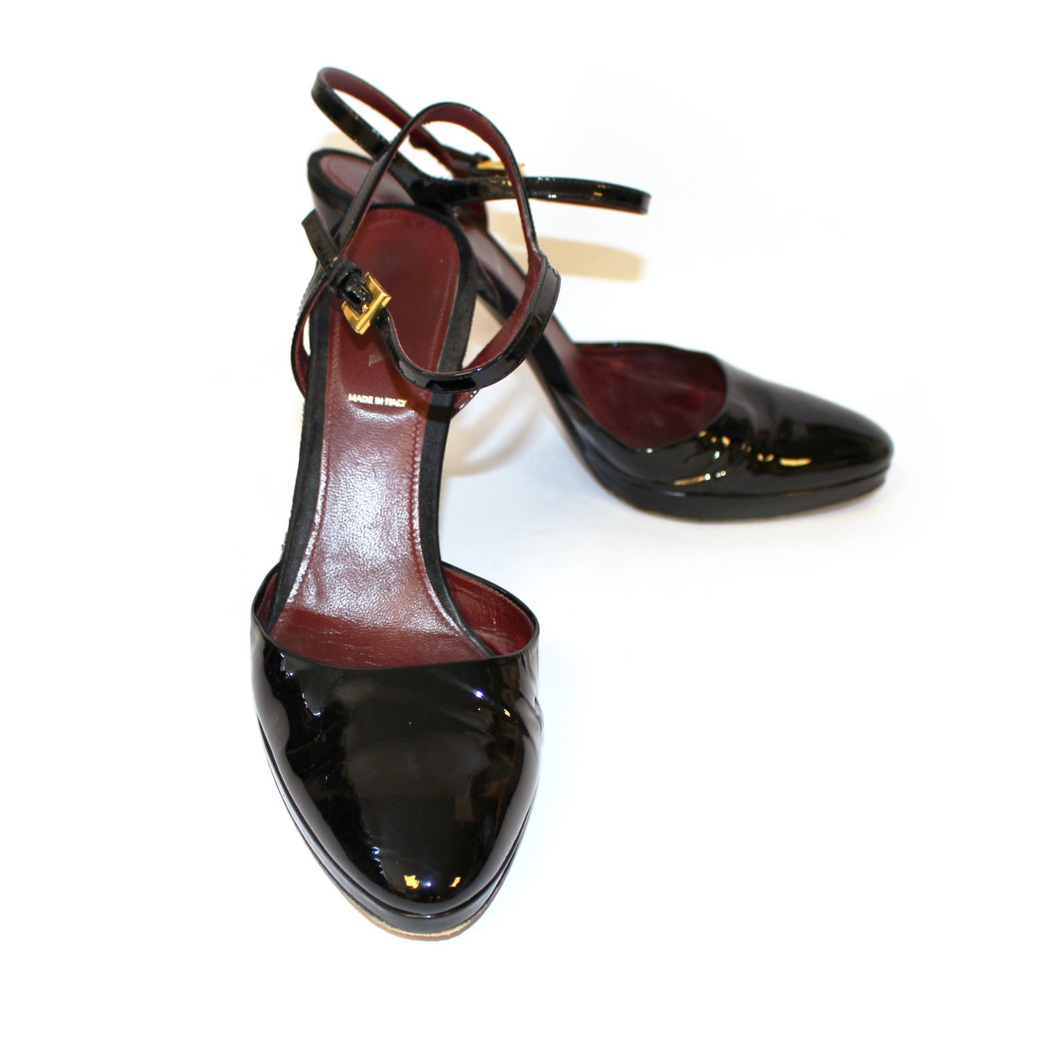 PRADA, BLACK PATENT LEATHER HEELS The heel strap with gilt metal buckles (size 39.5). (heel 11cm) B