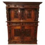 A 17TH CENTURY FLEMISH WALNUT COURT CUPBOARD Heavily carved with figures and lion and cherub