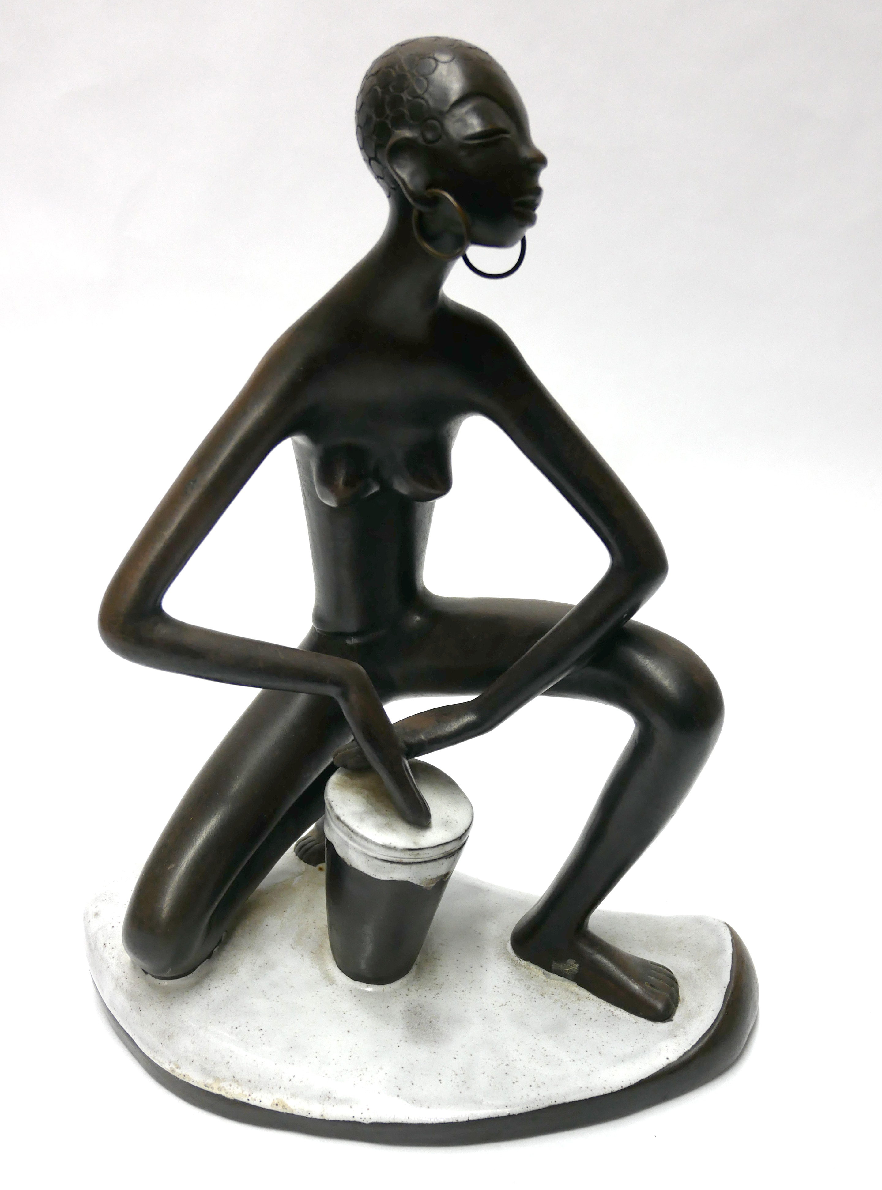 LEOPOLD ANZENGRUBER, A MID 20TH AUSTRIAN POTTERY FIGURINE Native African drummer with elongated