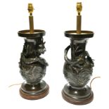 A PAIR OF JAPANESE MEIJI BRONZE LAMPS Each having an entwined dragon among stylised clouds, raised