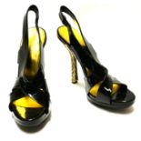 BALENCIAGA, A PAIR OF BLACK PATENT LEATHER SLINGBACKS With gilt enamelled heels (size 40).