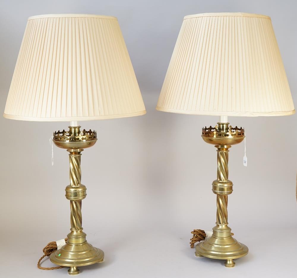 A PAIR OF VICTORIAN GOTHIC BRASS ALTAR CANDLESTICK TABLE LAMPS With pierced tops over candy twist