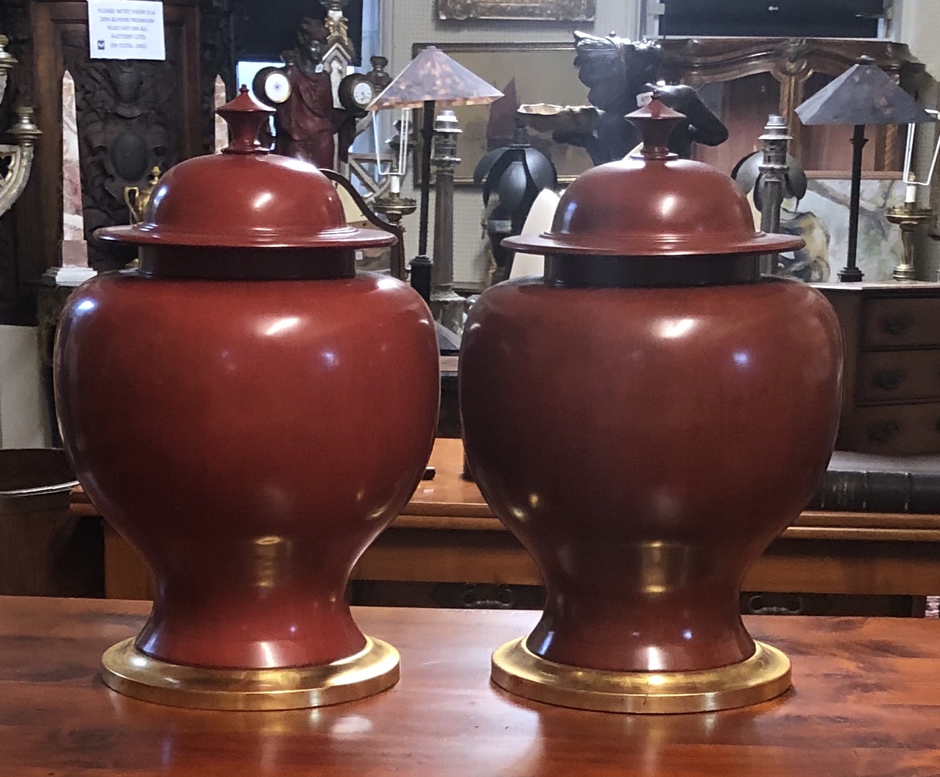 TWO LARGE CERAMIC BALUSTER VASES AND COVERS In red oxide, on giltwood stands. (53cm)