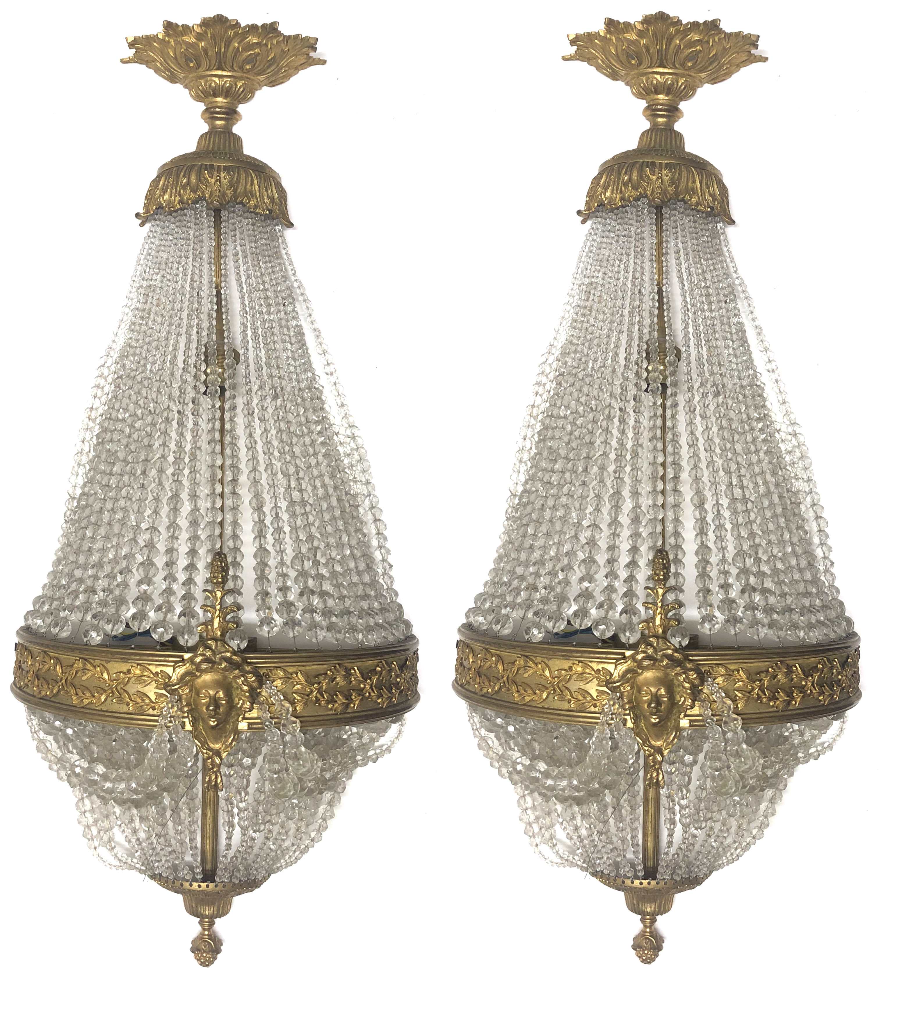 A PAIR OF VENETIAN STYLE BRONZE BASKET WALL LIGHTS With beaded glass shades, the lower with