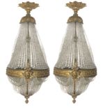 A PAIR OF VENETIAN STYLE BRONZE BASKET WALL LIGHTS With beaded glass shades, the lower with