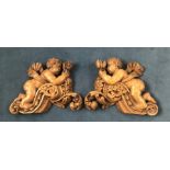 A PAIR OF 19TH CENTURY OAK CARVINGS Winged cherubs resting on foliage. (55cm x 44cm)