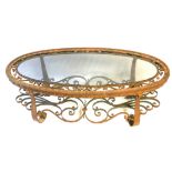 AN EARLY 20TH CENTURY WROUGHT IRON OVAL COFFEE TABLE With inset glass top and scroll work