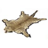A leopard-skin rug, late 19th/early 20th century, with a full head and claws, mounted on a felt