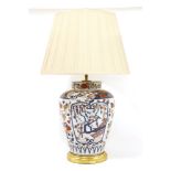 A table lamp,in the form of an ovoid vase with Imari-style decoration on a turned giltwood base,vase