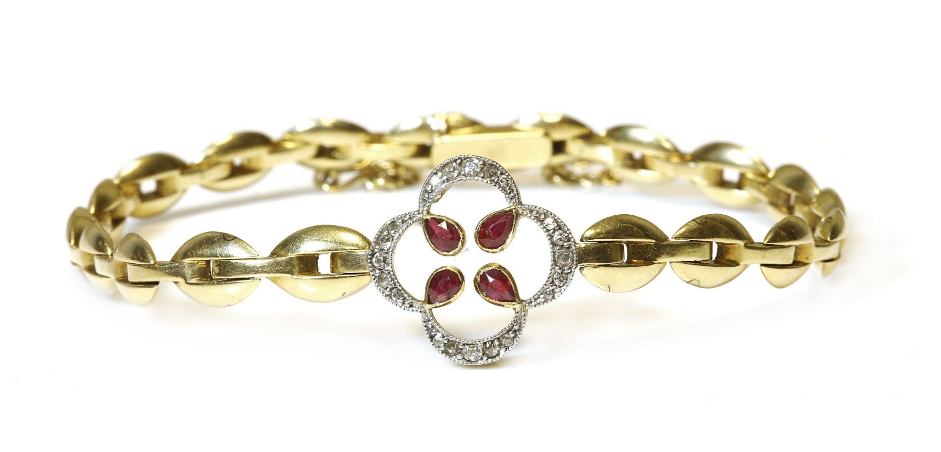 A gold ruby and diamond quatrefoil bracelet,four pear-shaped rubies, rub set to an open quatrefoil