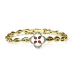A gold ruby and diamond quatrefoil bracelet,four pear-shaped rubies, rub set to an open quatrefoil