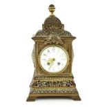 A mantel clock,late 19th century, the French movement to an enamel dial, within an ornate brass