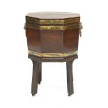 A George III mahogany octagonal brass bound wine cooler,with a crossbanded top above lion's mask