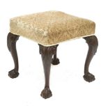 A Chippendale-style footstool,19th century, the upholstered seat on carved mahogany claw and ball