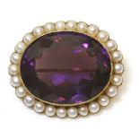 An gold amethyst and split pearl brooch,an oval mixed cut amethyst rub set to a reeded textured