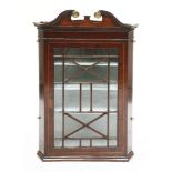 A George III-style mahogany hanging corner cupboard,late 19th century, with a scrolled cornice and
