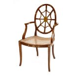 An Edwardian mahogany elbow chair,with an oval back, scrolled arms, a carved seat and out-splayed