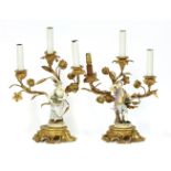 A pair of gilt bronze three-branch candelabra,19th century, each mounted with a Meissen-style figure