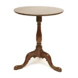 A George III mahogany tripod table,the circular top on a baluster column and outswept legs,59cm