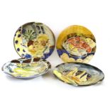 Four modern pottery wall plates,brightly painted with still lifes, indistinctly signed and dated