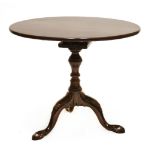 A mahogany tripod table, with a single piece top on a baluster column with birdcage action, carved