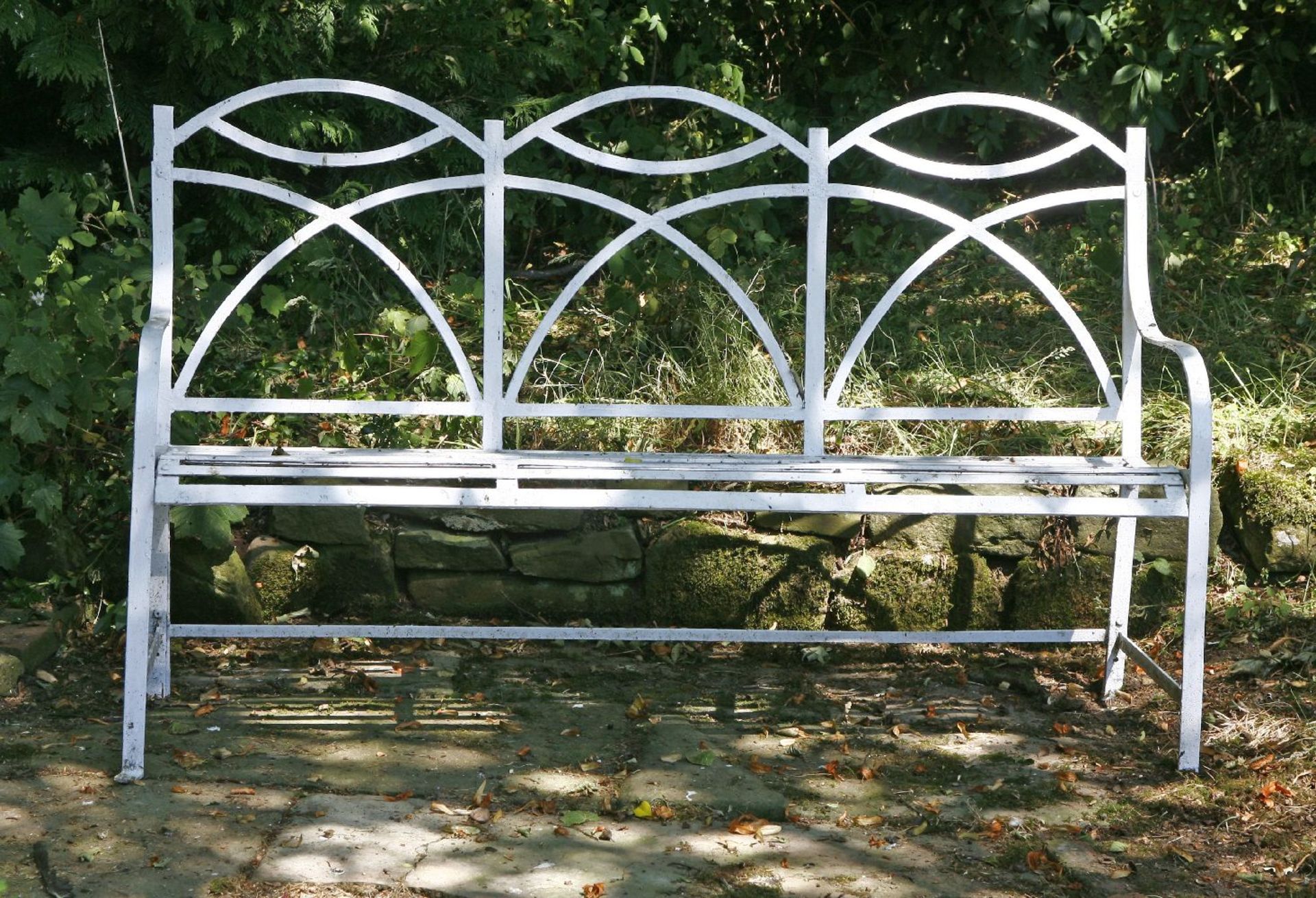 A Regency-style painted iron garden seat,with an arched three-seat back over a slatted seat,55cm