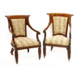 A pair of Regency mahogany and rosewood library chairs,with upholstered backs, lappet carved and