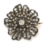 A Victorian diamond set flower head brooch,a cushion cut diamond, claw set to the centre of the