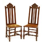 A pair of walnut single chairs,the high backs with scrolled crests, carved with wheat ears and 'S