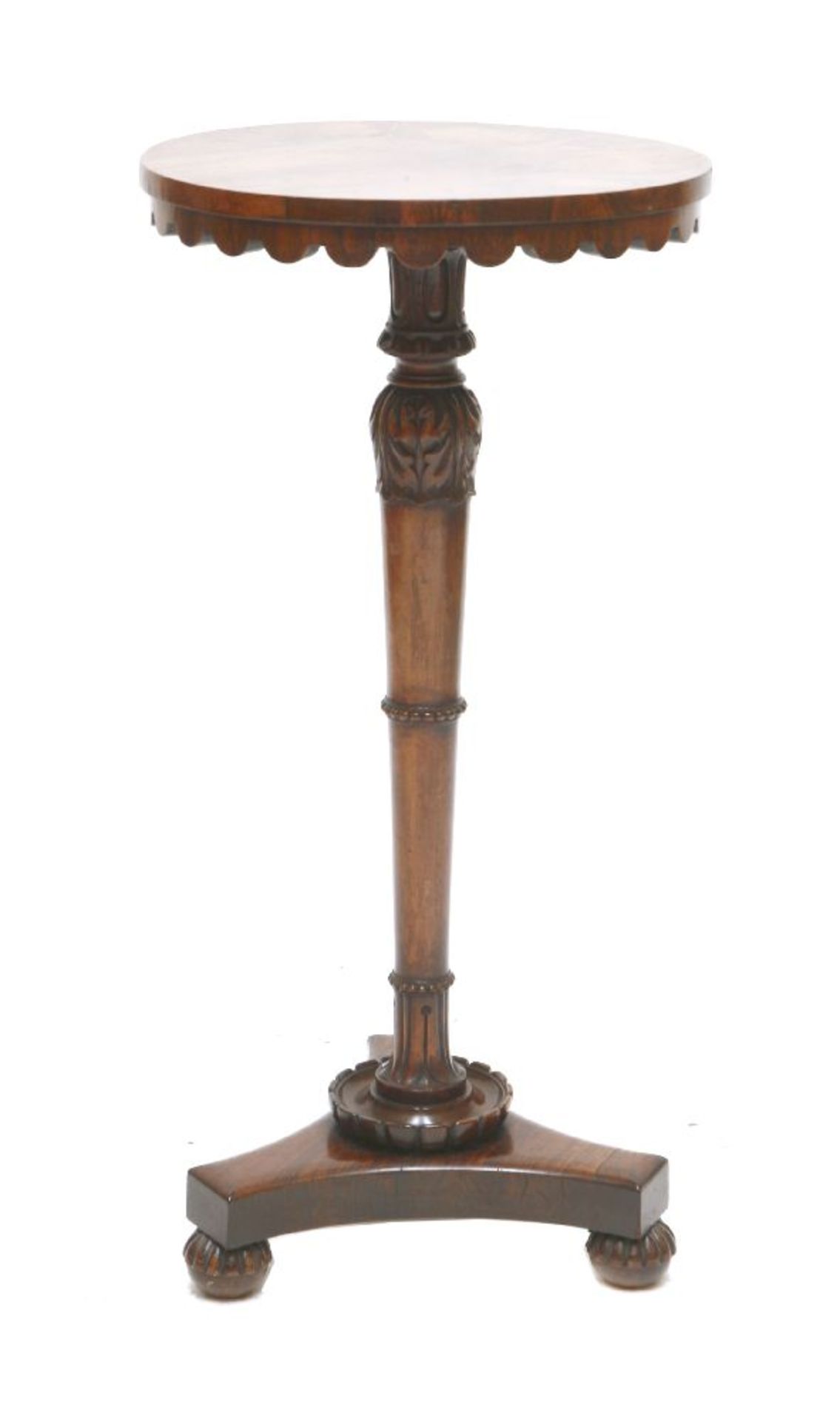 A William IV rosewood lamp table,the circular top with a wavy frieze on a carved, turned, tapering