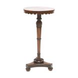 A William IV rosewood lamp table,the circular top with a wavy frieze on a carved, turned, tapering