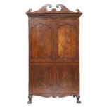 A mahogany armoire,19th century, having a scrolled cornice over two doors, each with two shaped