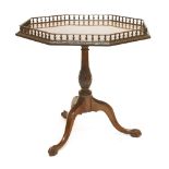 A George III mahogany tripod table, the octagonal top with a turned gallery and carved border, on